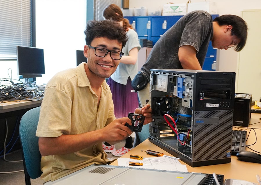 Student fixing computer hardware